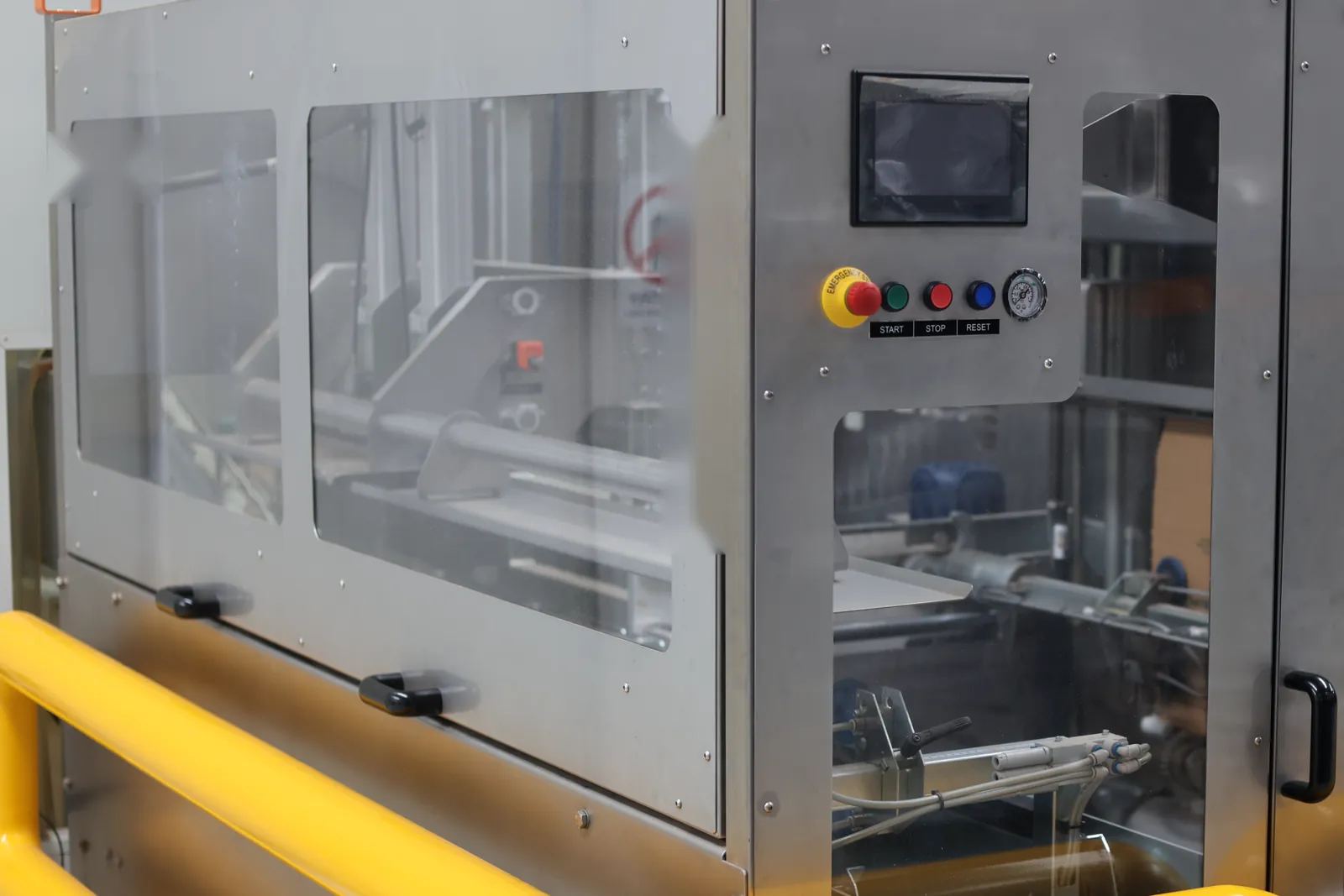 The automatic case packer, with its stainless-steel guarding and control panel