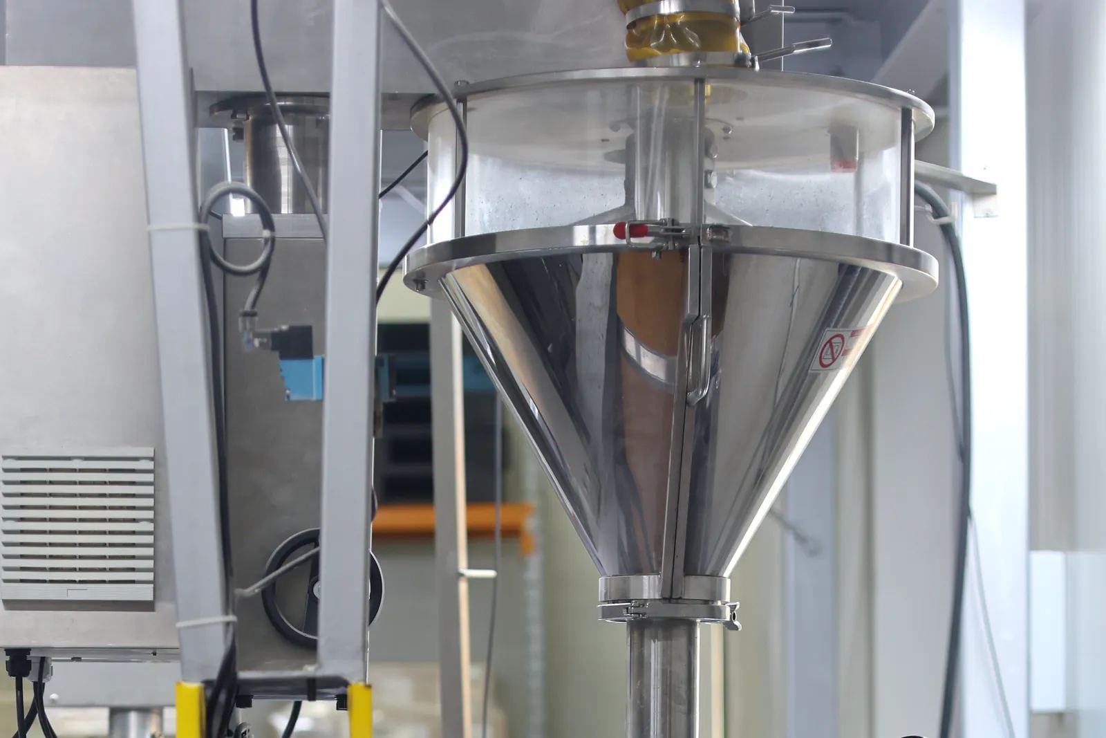 The polished stainless-steel hopper on the filling line